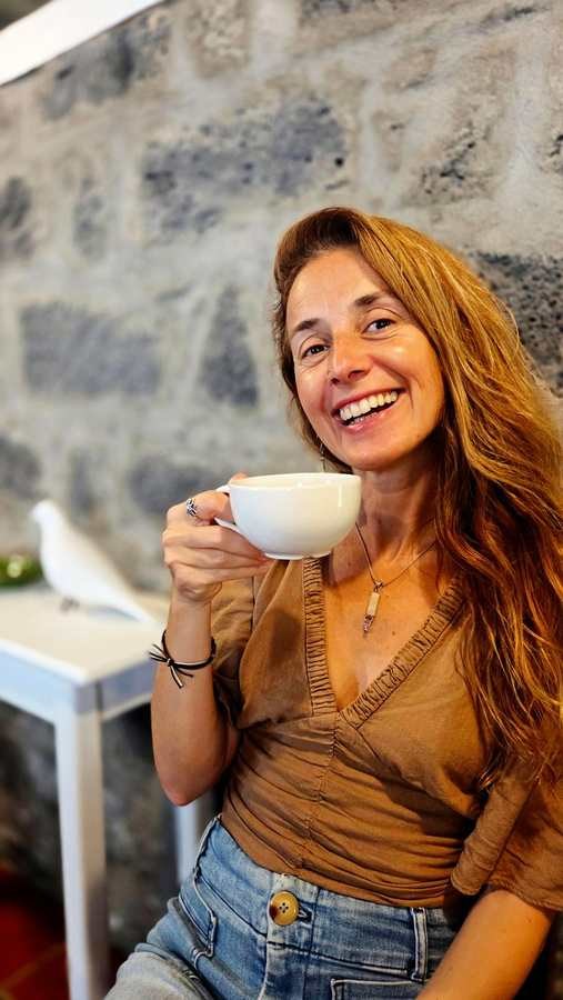 Danielle Sadhana smiling, holding a cup of tea